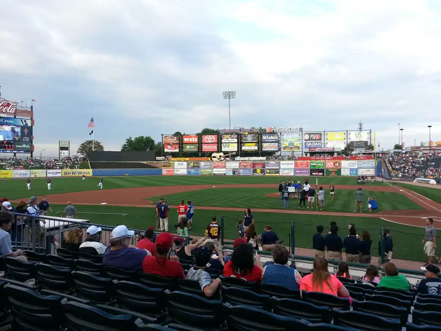 Fans in the field-level seats at Coca-Cola Park in Allentown on a game day, with the Coca-Cola sign in left field